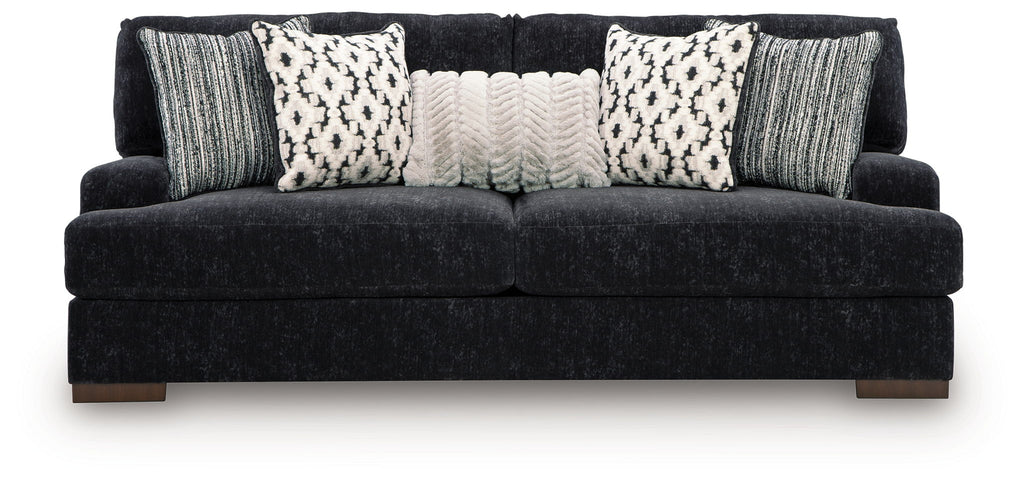 Dark fabric sofa with three patterned pillows and two gray knit cushions, wide seat