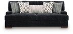 Dark fabric sofa with three patterned pillows and two gray knit cushions, wide seat