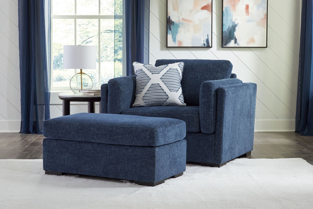 Blue armchair and ottoman set with patterned throw pillows and textured upholstery