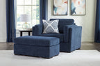 Blue armchair and ottoman set with patterned throw pillows and textured upholstery