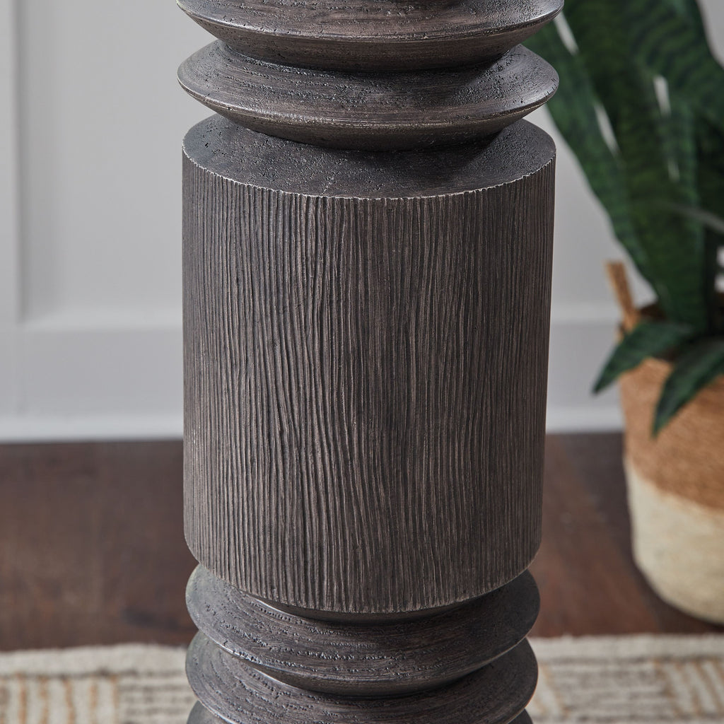 Distressed dark floor lamp column with stacked ribbed segments, close-up detail