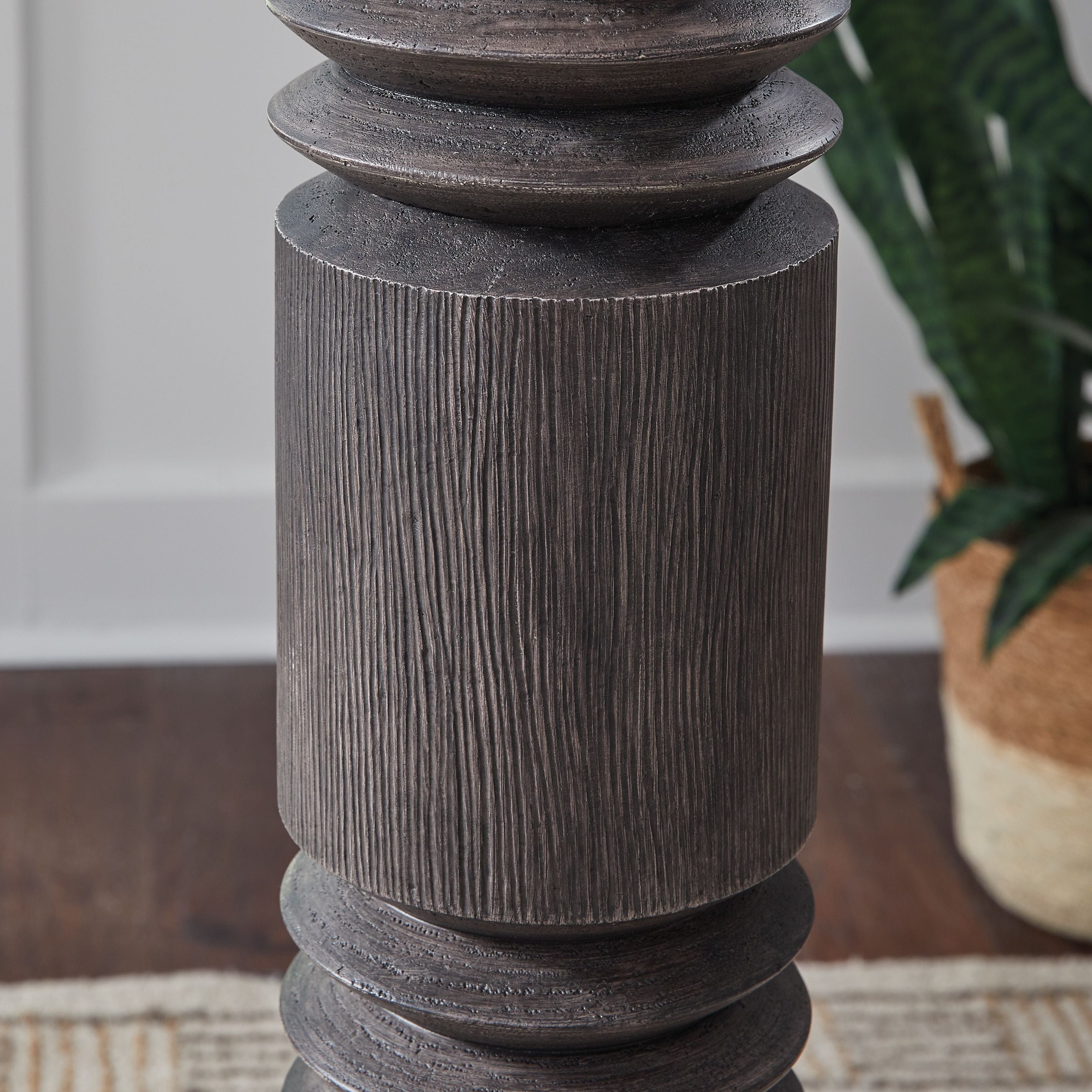 Distressed dark floor lamp column with stacked ribbed segments, close-up detail