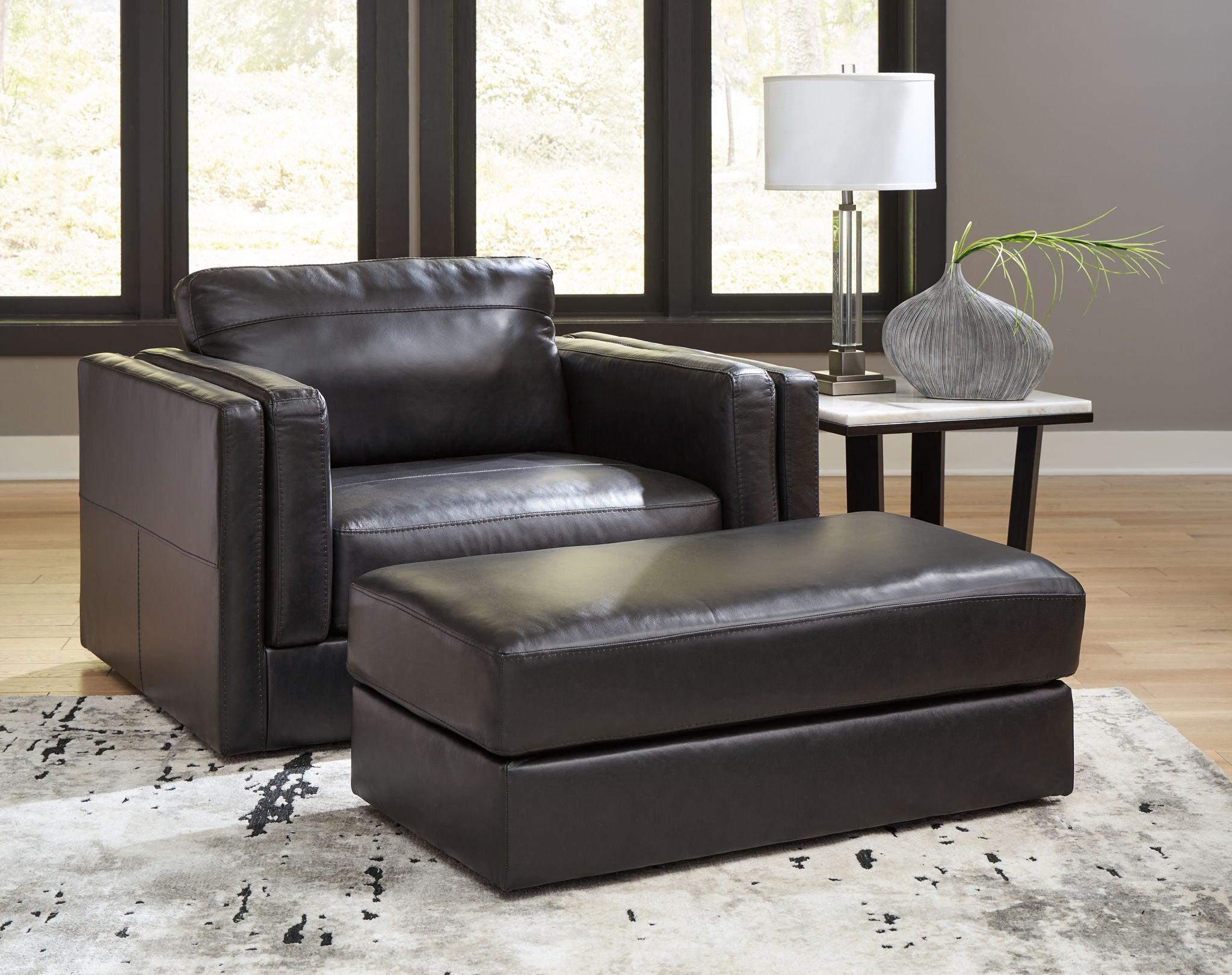Black leather armchair with matching ottoman in front