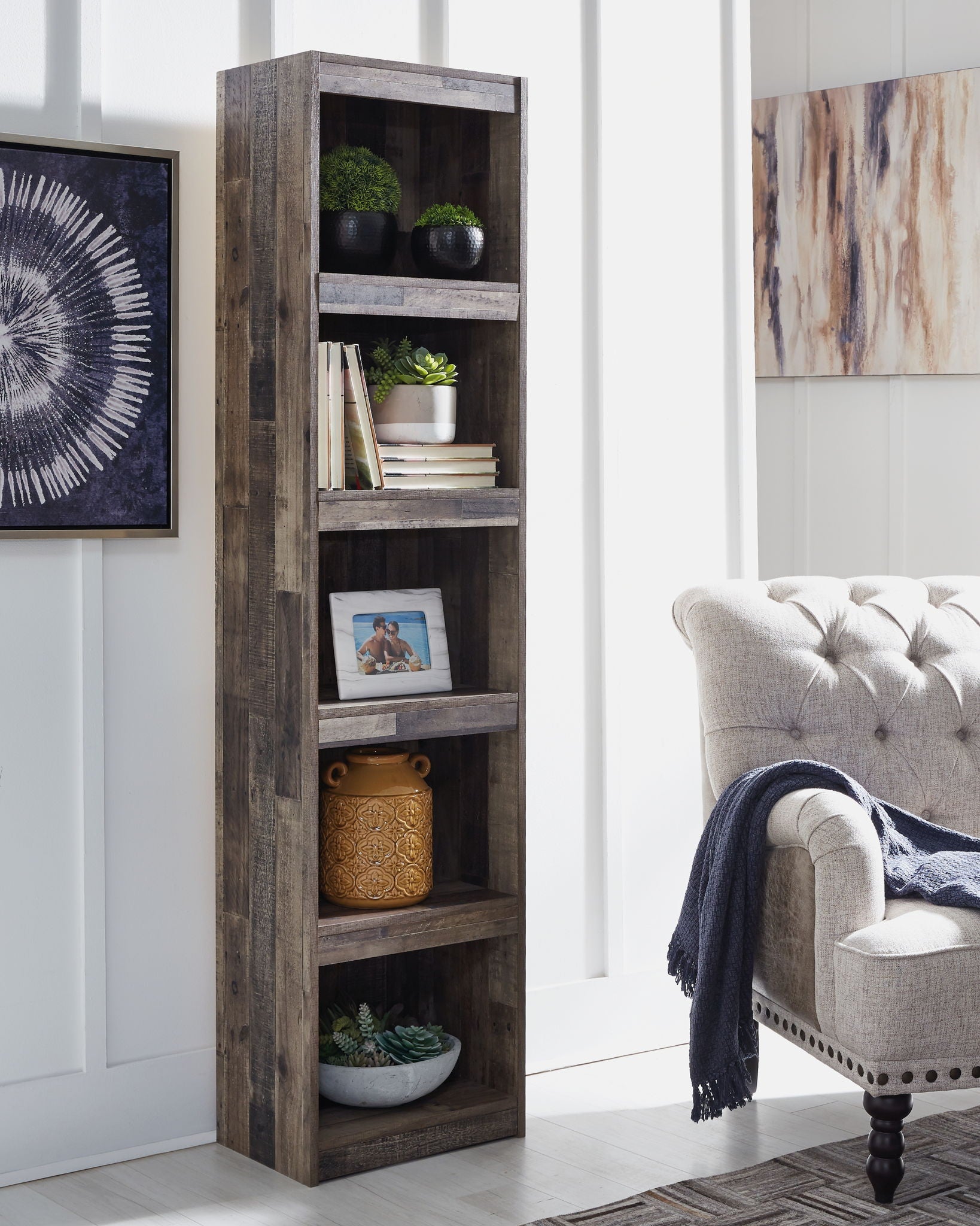 Reclaimed-style gray bookcase with multiple open shelves holding decor
