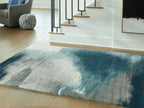 Blue abstract area rug with cream highlights, distressed texture