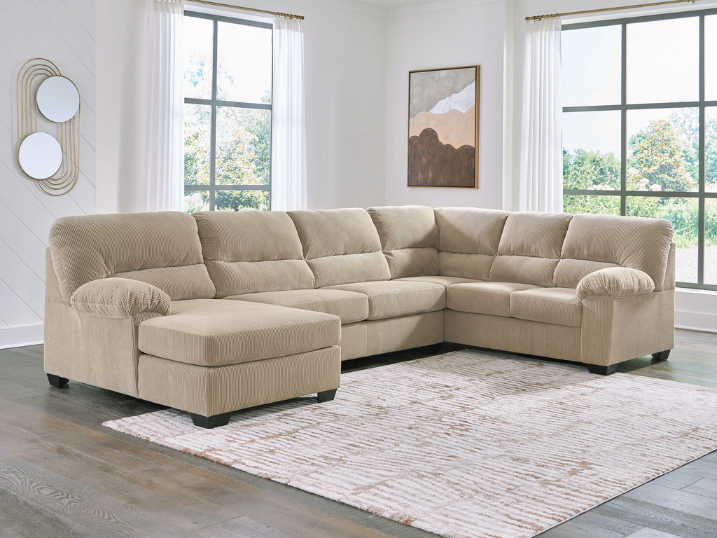 Light beige sectional sofa with corner chaise, tufted back, rounded arms, plush cushions