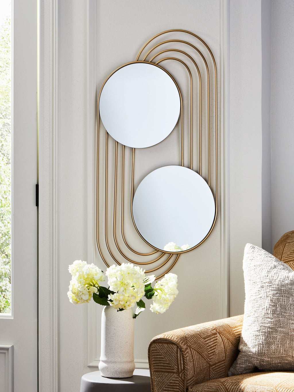 Gold-finish accent wall mirror mounted with two round mirrors and arched metal lines