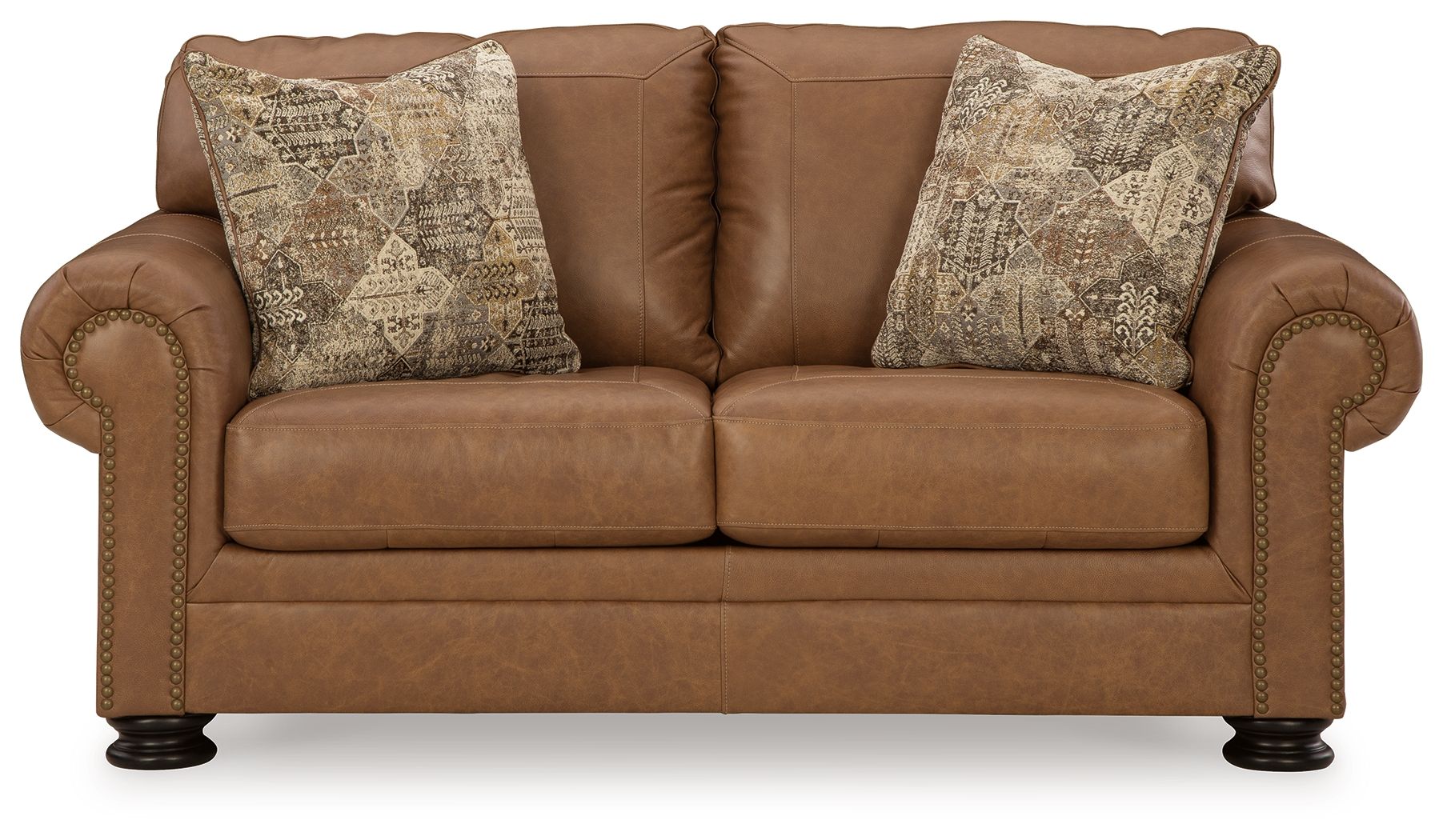 Caramel loveseat with two patterned pillows and tufted arm panels