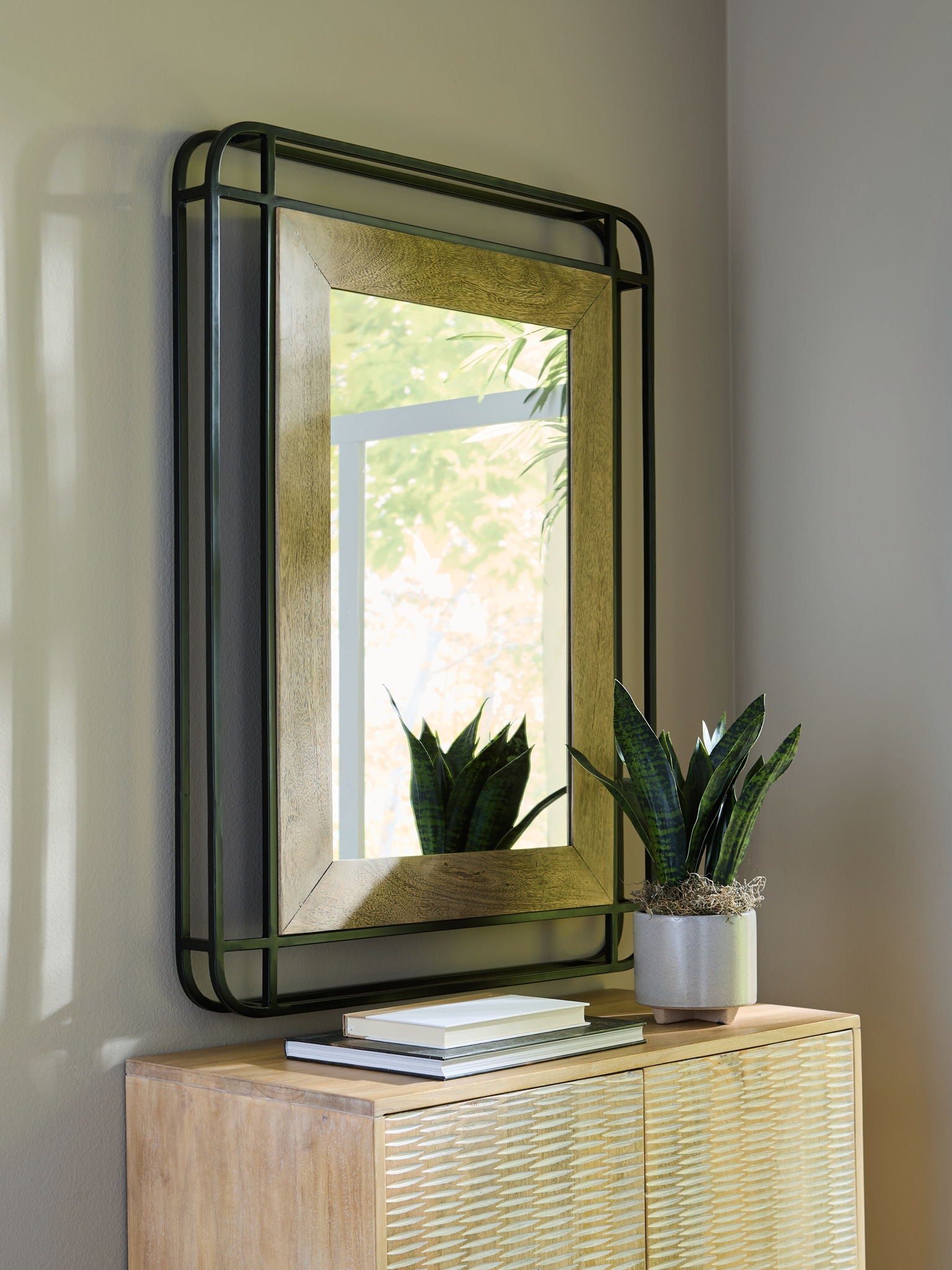 Accent mirror with black metal frame and wood-tone edge, rectangular glass panel