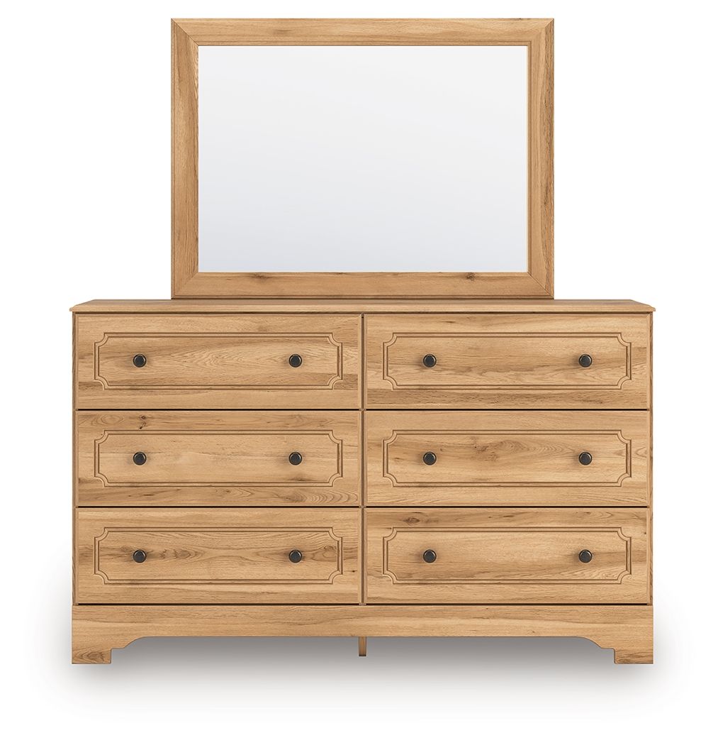 Light brown dresser with framed mirror and six drawers with black knobs