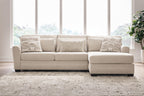 Light beige sectional sofa with chaise, tufted cushions and two patterned accent pillows
