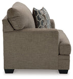 Brown chair-and-a-half armchair with geometric throw pillow and thick arm padding