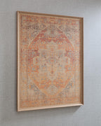 Framed wall art with red-orange geometric motif and muted blue accents on wall