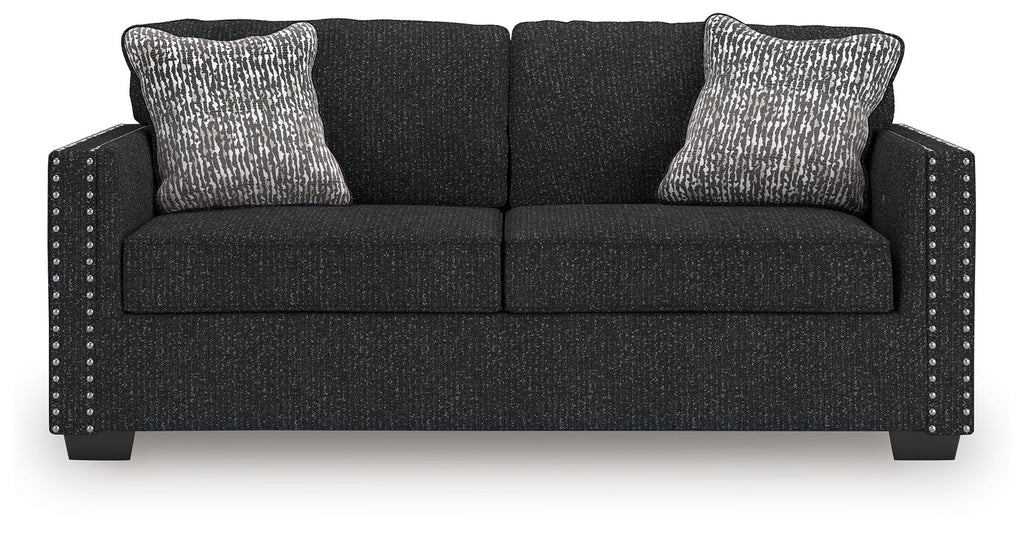 Black textured loveseat with two seat sections and two patterned throw pillows
