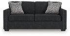 Black textured loveseat with two seat sections and two patterned throw pillows