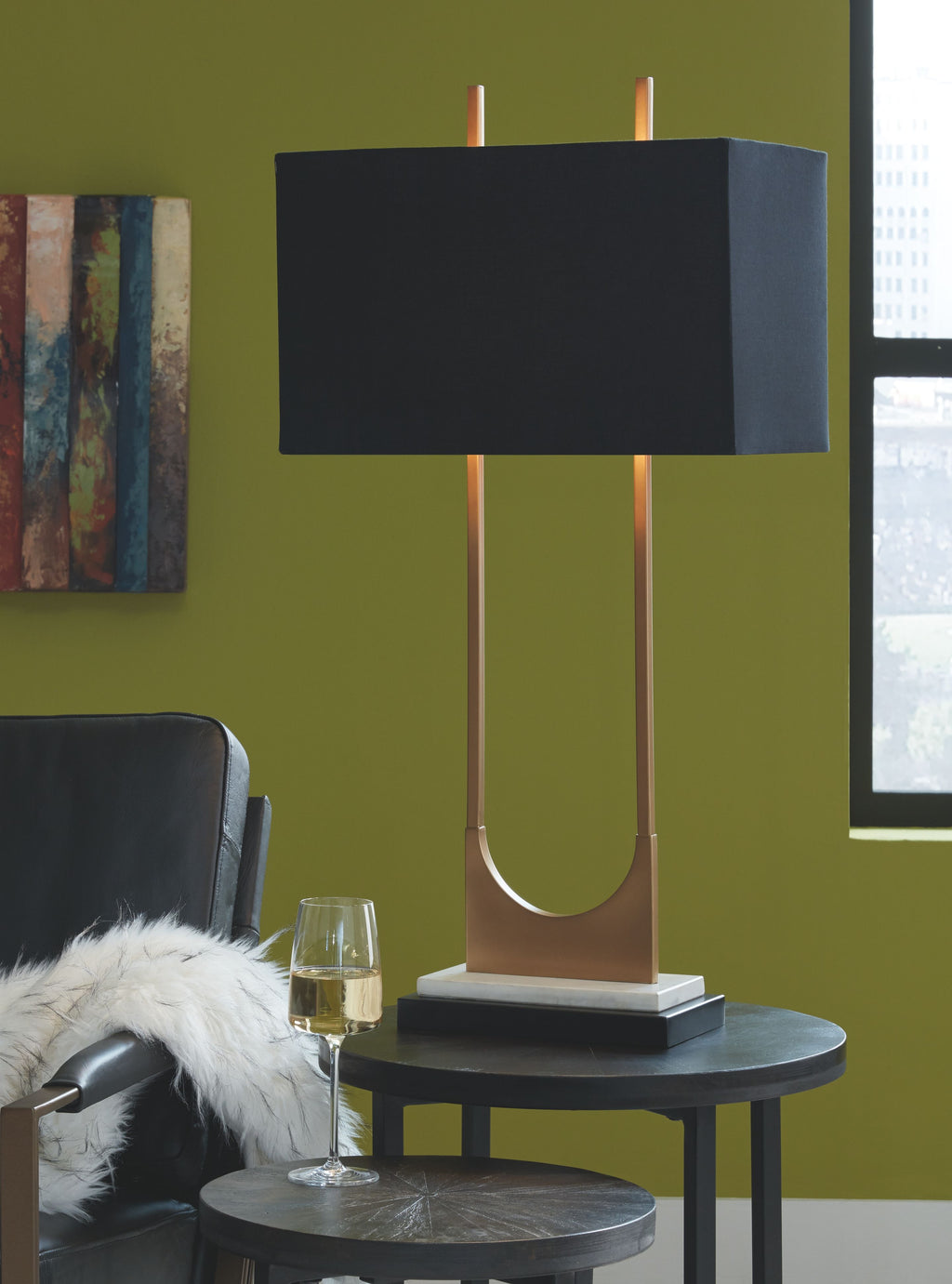 Brass table lamp with black rectangular shade, dark base, and curved U metal support