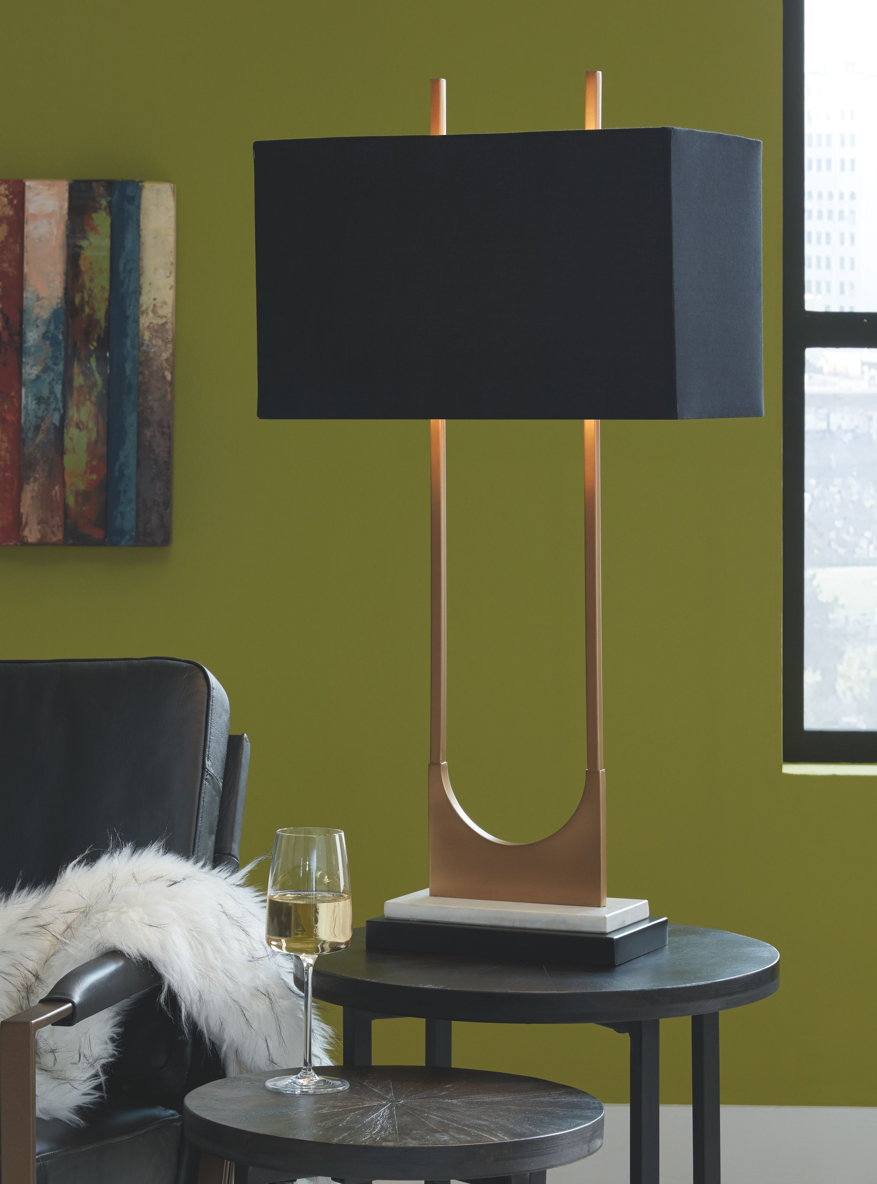 Brass table lamp with black rectangular shade, dark base, and curved U metal support