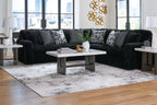 Black corduroy sectional sofa with chaise and patterned accent pillows