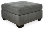 Slate gray upholstered ottoman with tufted top and dark wooden legs