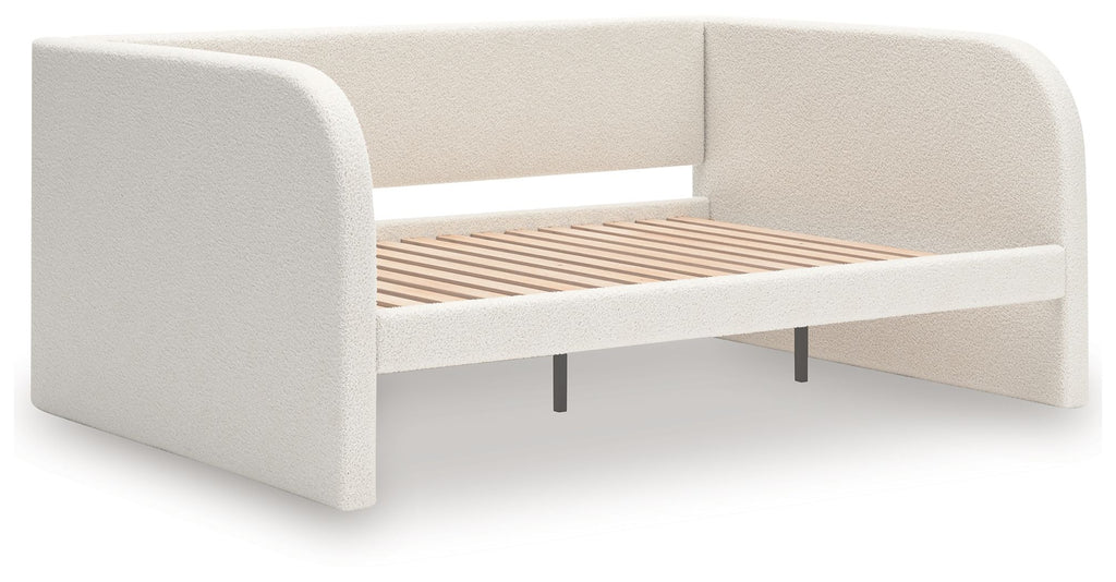 Upholstered day bed in beige fabric with white cushions; wooden slat base