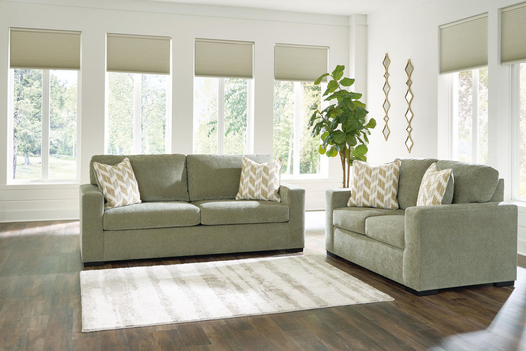 Living room set: green sofa and loveseat with beige and gray patterned throw pillows
