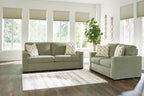 Living room set: green sofa and loveseat with beige and gray patterned throw pillows