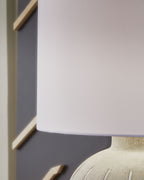 Warm gray ribbed poly table lamp base with white drum shade corner