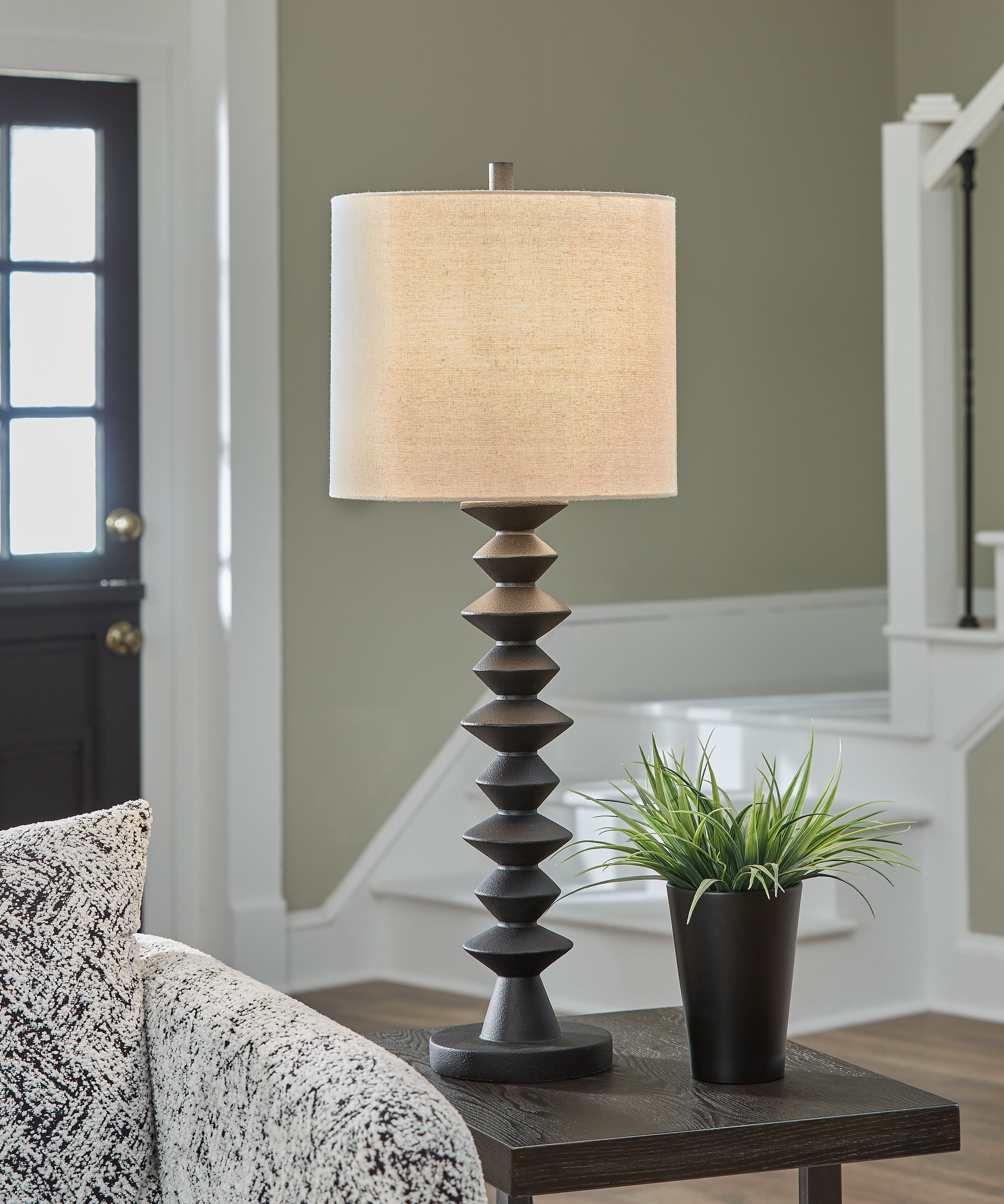 Black poly buffet lamp with beige fabric drum shade and stacked geometric base