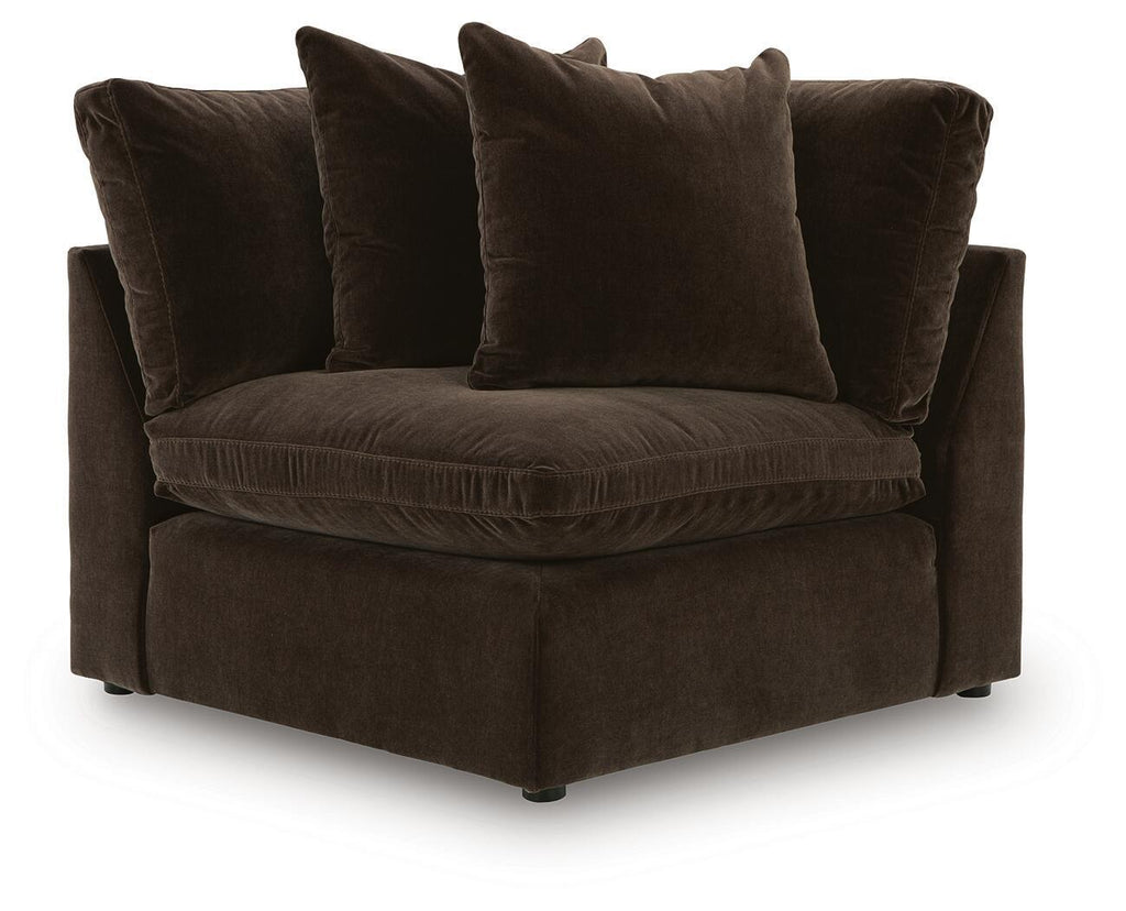 Dark brown fabric wedge sofa with padded arms and seat cushion, plus three throw pillows