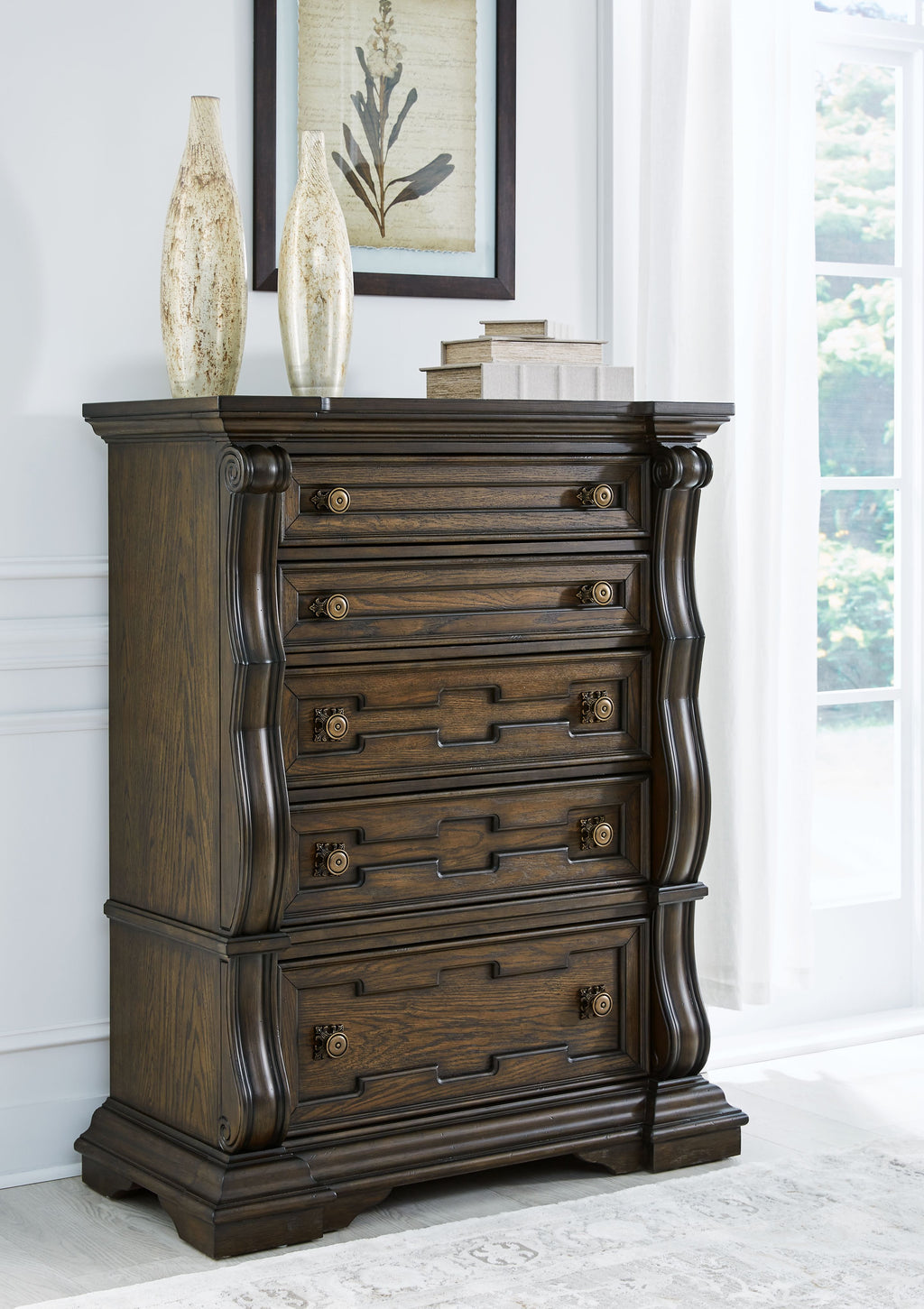 Dark brown five-drawer chest with brass-tone pulls, angled view