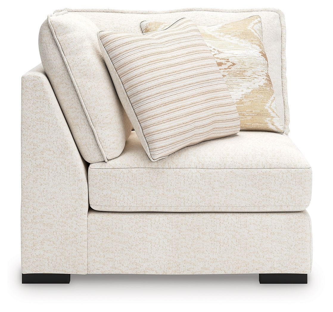 Corner chair with vanilla-beige fabric, single patterned pillow, and low dark feet
