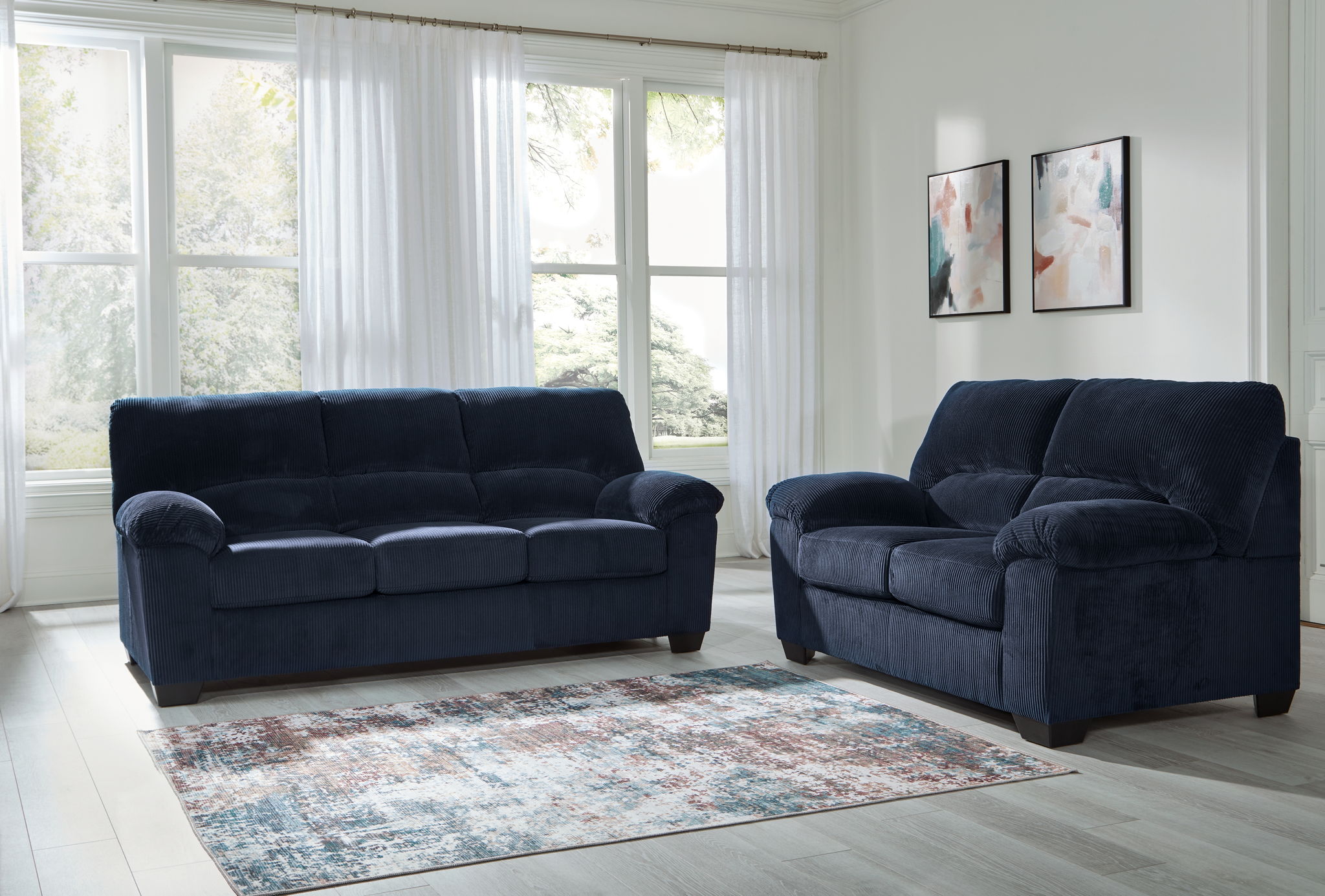 Dark blue sofa and loveseat set with padded armrests