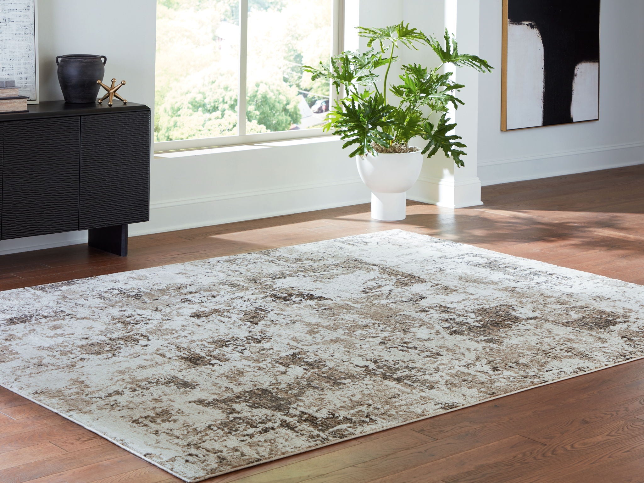 Large distressed gray-and-beige area rug in a living room setting with furniture nearby.