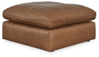 Light brown oversized accent ottoman with rounded upholstered top and padded base