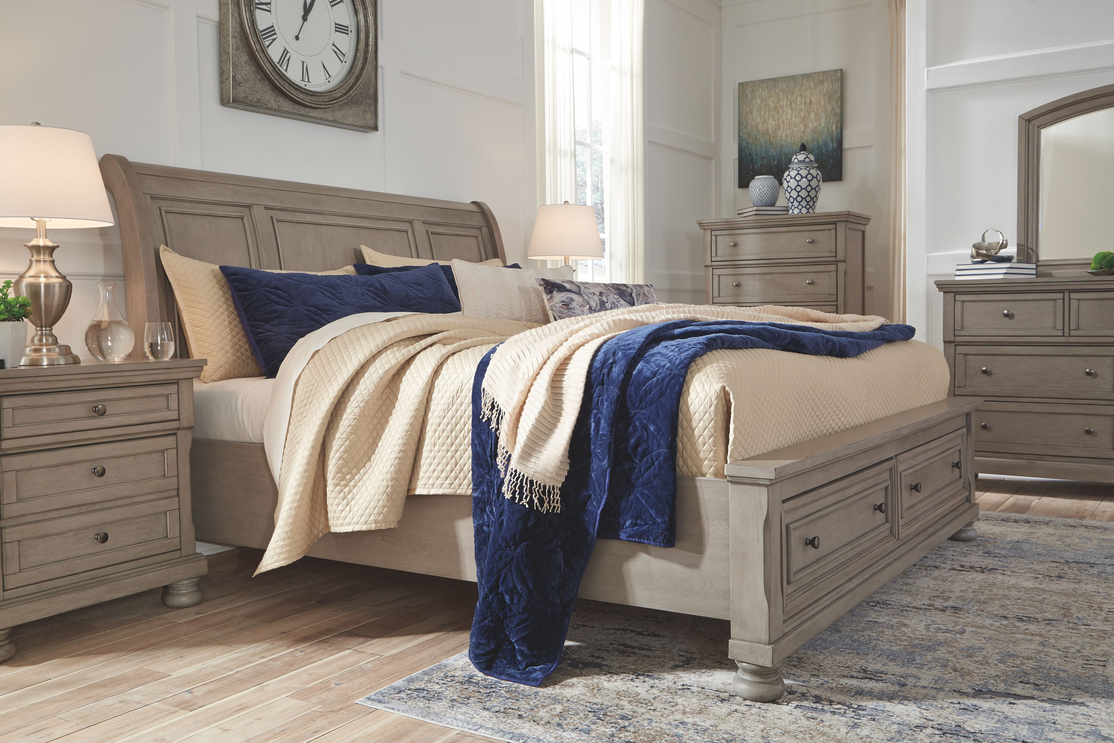 Light gray sleigh bedroom set with sleigh bed, nightstand, and dresser pieces