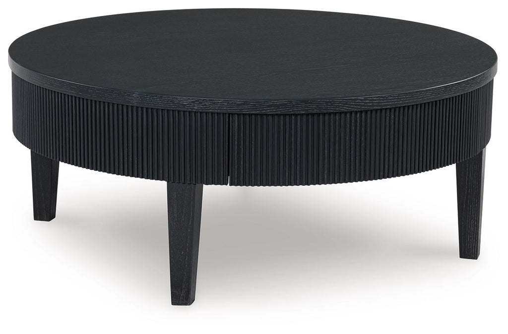 Black round cocktail table with ribbed pedestal sides and dark legs