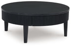 Black round cocktail table with ribbed pedestal sides and dark legs