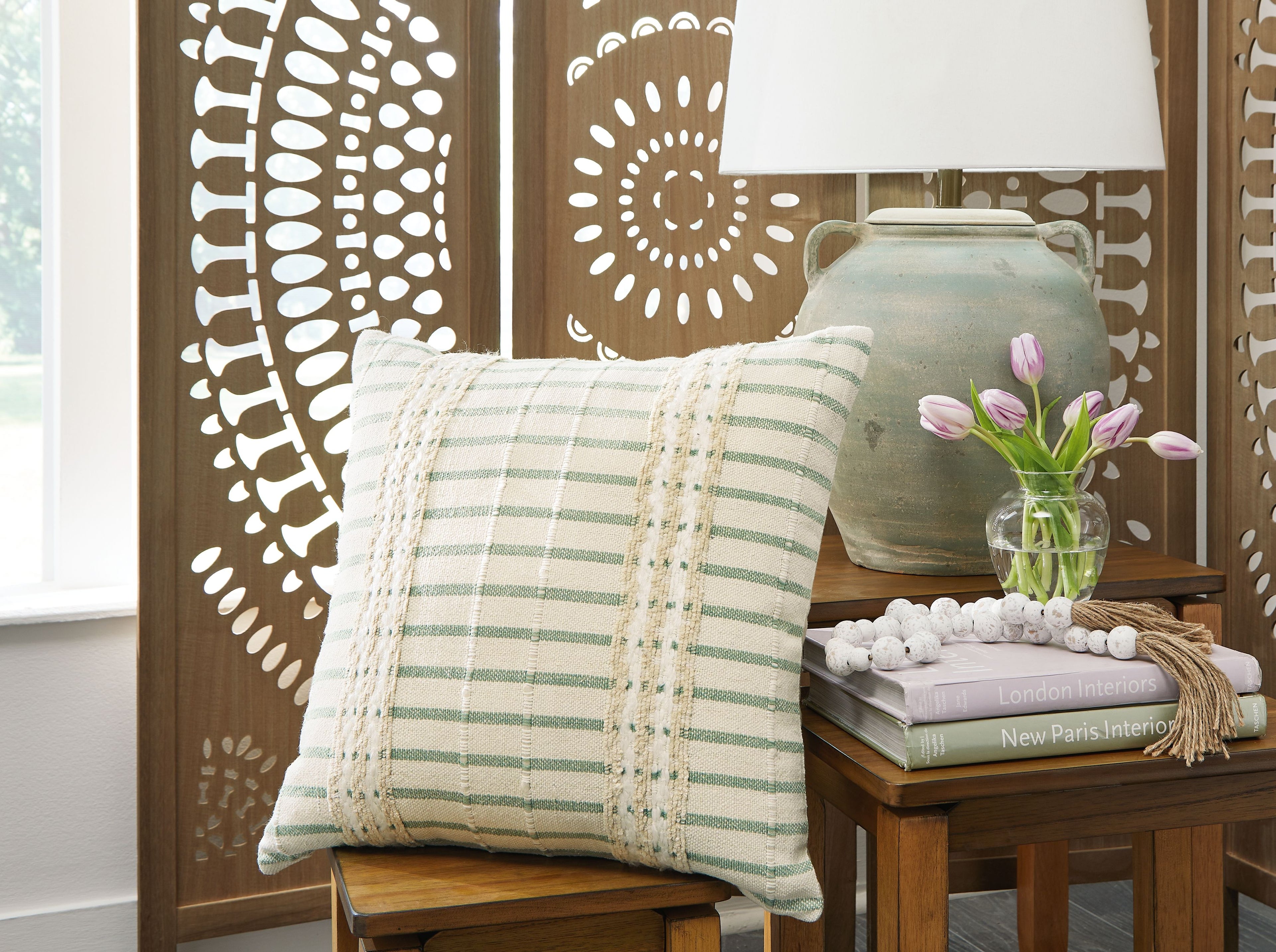 Green-and-white striped pillow with beige embroidered trim