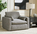 Gray upholstered accent chair with wide arms and matching throw pillow