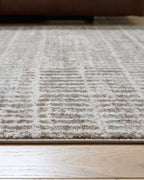 Gray area rug close-up with low-pile woven lines and speckled pattern