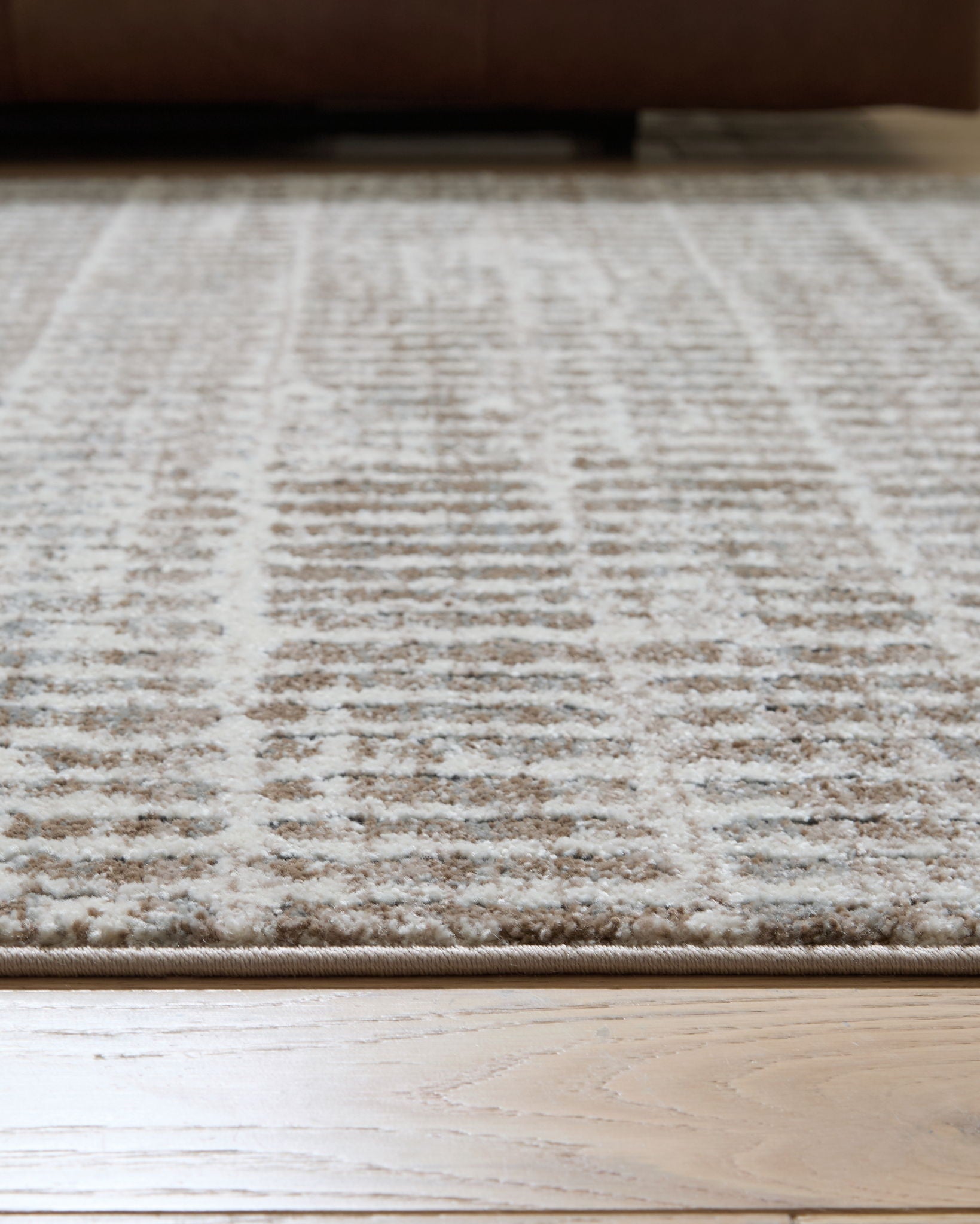 Gray area rug close-up with low-pile woven lines and speckled pattern