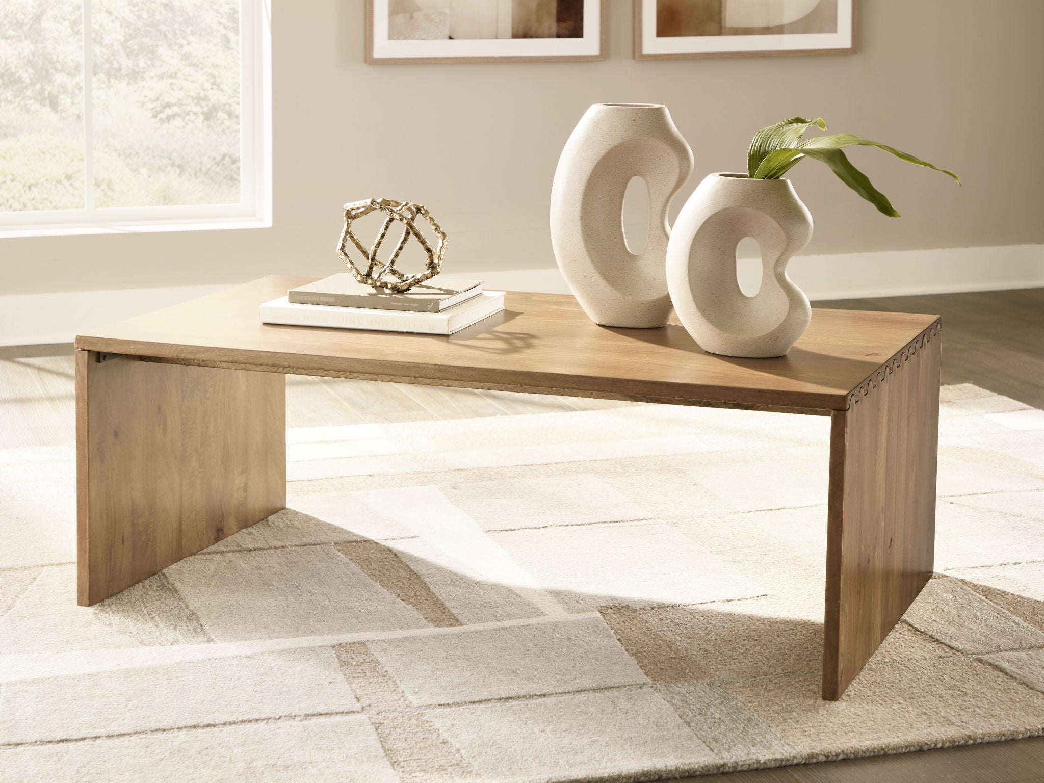 Light brown rectangular table with open shelf, styled with decor and books