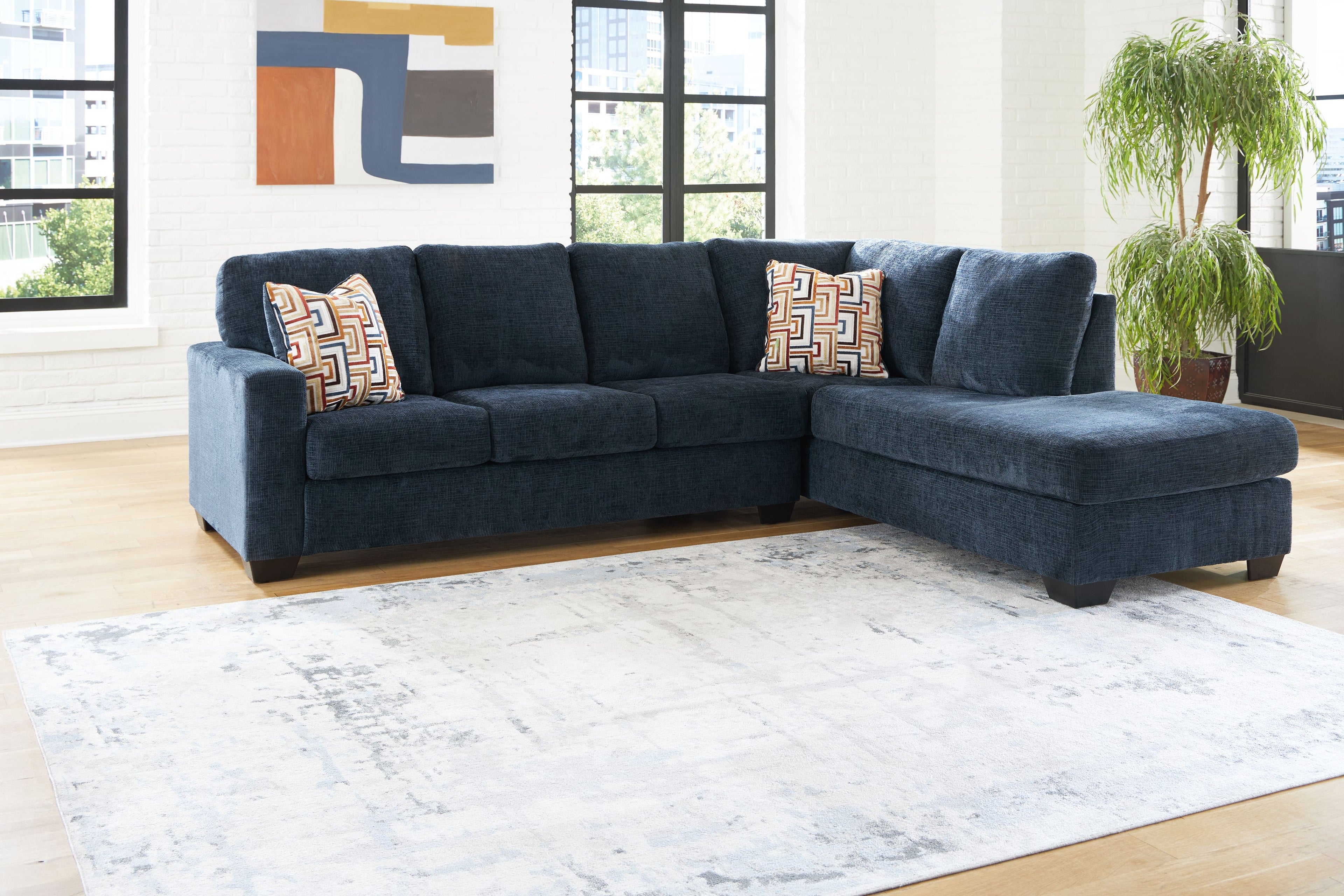 Dark blue corner chaise sectional sofa with geometric accent cushions