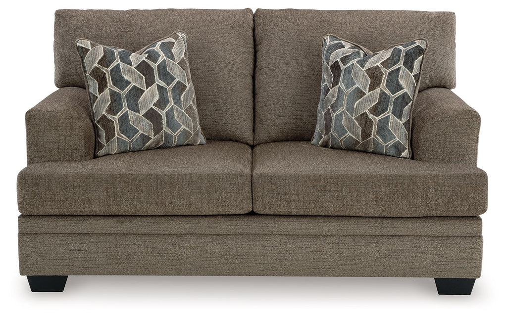 Light beige fabric loveseat with two geometric patterned pillows, front view