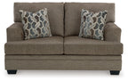 Light beige fabric loveseat with two geometric patterned pillows, front view
