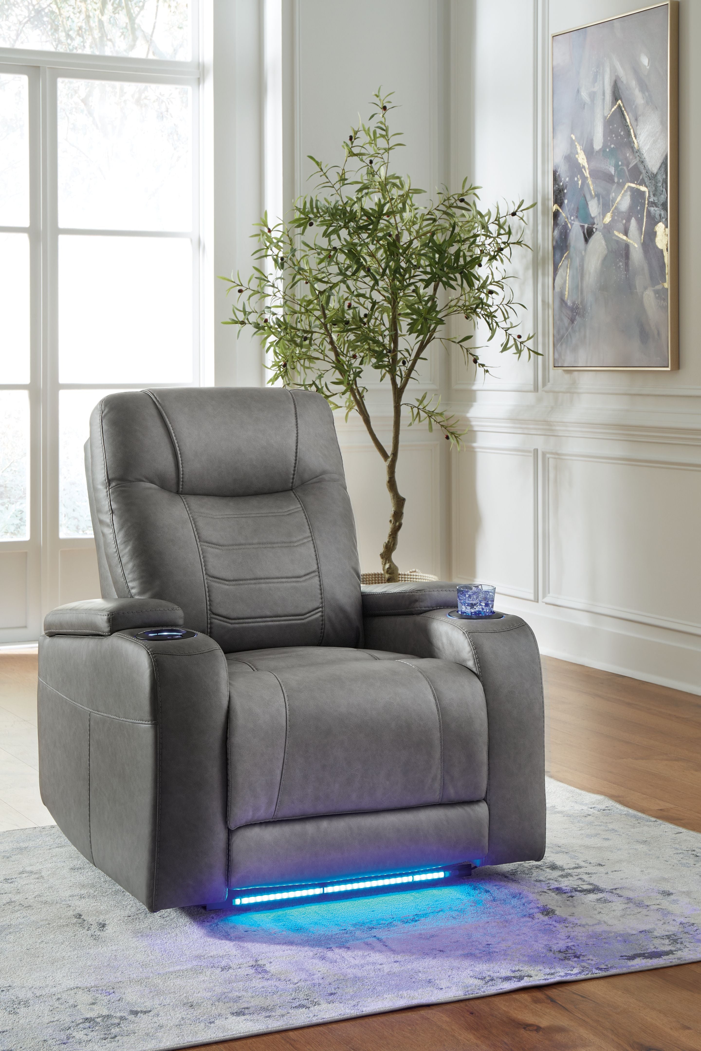 Slate gray power recliner with adjustable headrest and padded armrests, side view