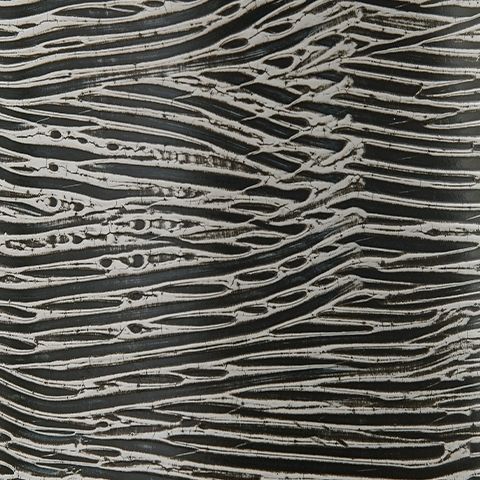Close-up of ceramic vase with dark base and light wavy etched lines pattern.
