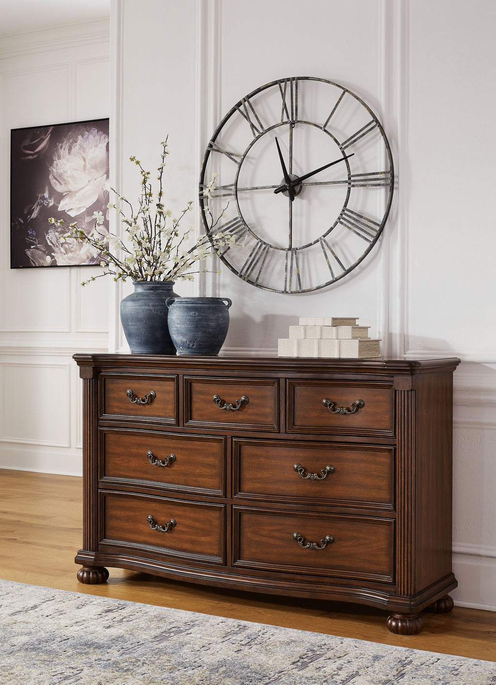 Brown wooden dresser with double rows of drawers and ornate metal pulls, tapered legs