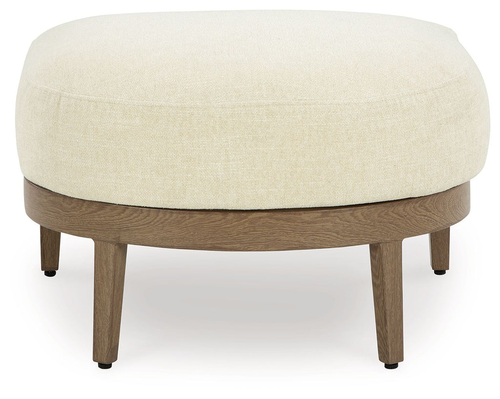 Round beige fabric ottoman with dark brown wooden legs
