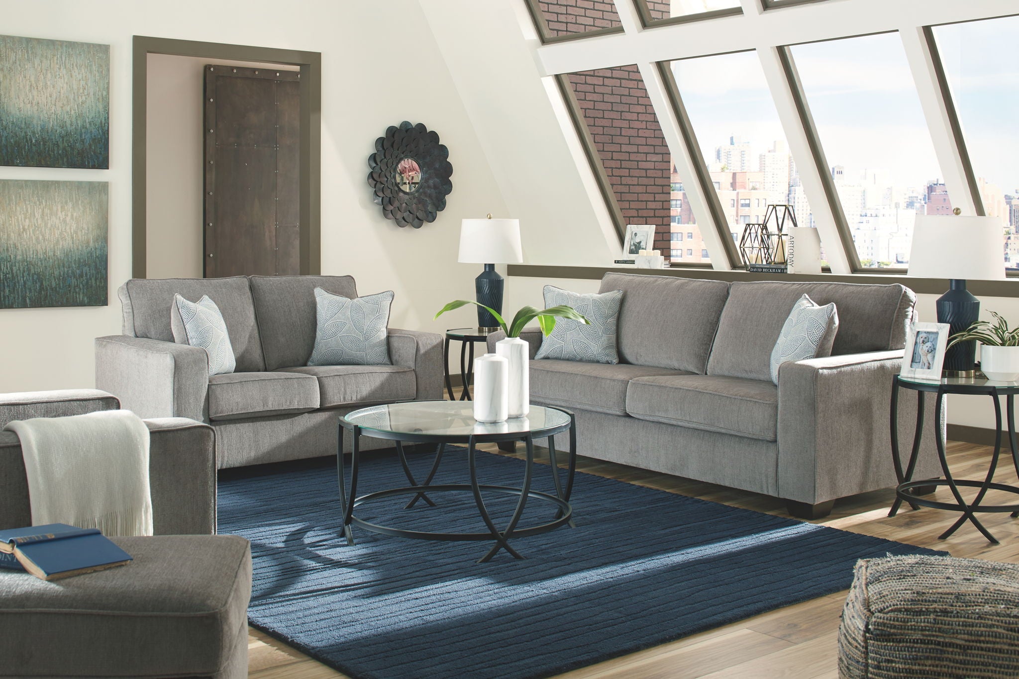 Gray fabric sofa and loveseat with blue accent throw pillows